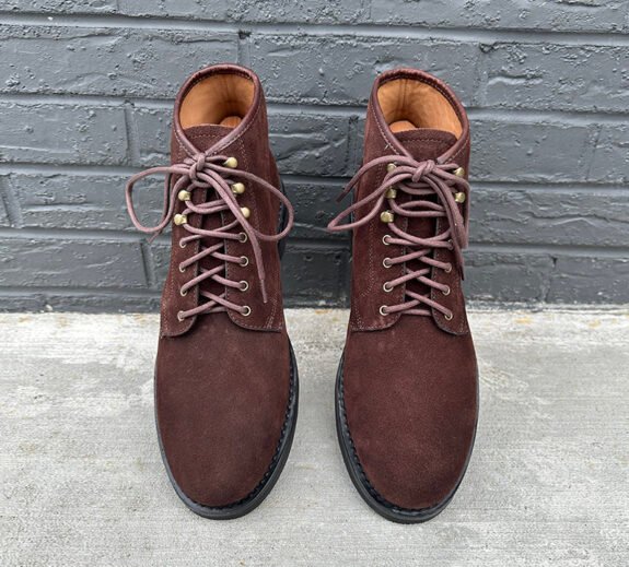 Bottes J. Crew Field en daim marron contre un mur de briques grises