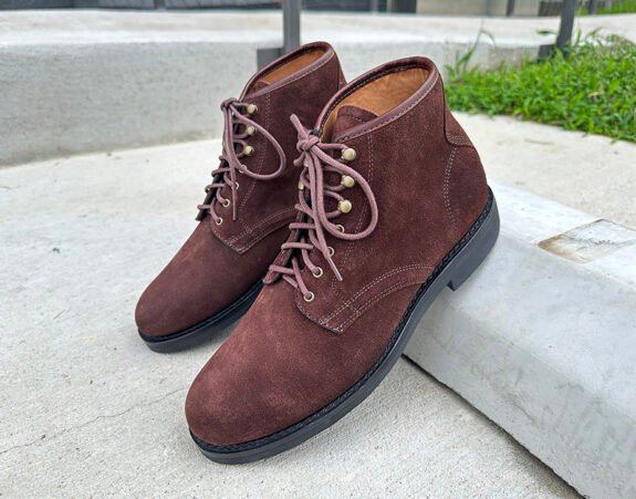 Bottes J. Crew Field en daim marron appuyées sur le trottoir