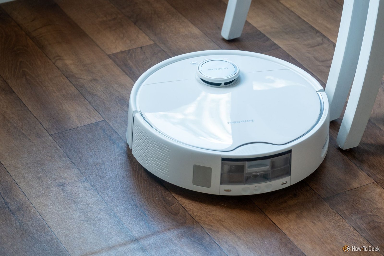 Robot aspirateur SwitchBot S10 faisant le tour d'une chaise.