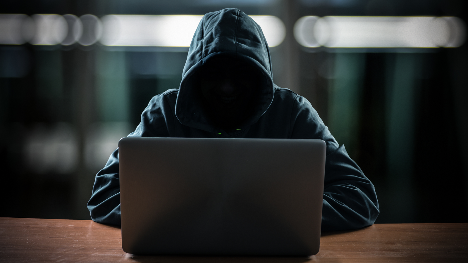 Hacker devant son ordinateur avec un visage sombre.