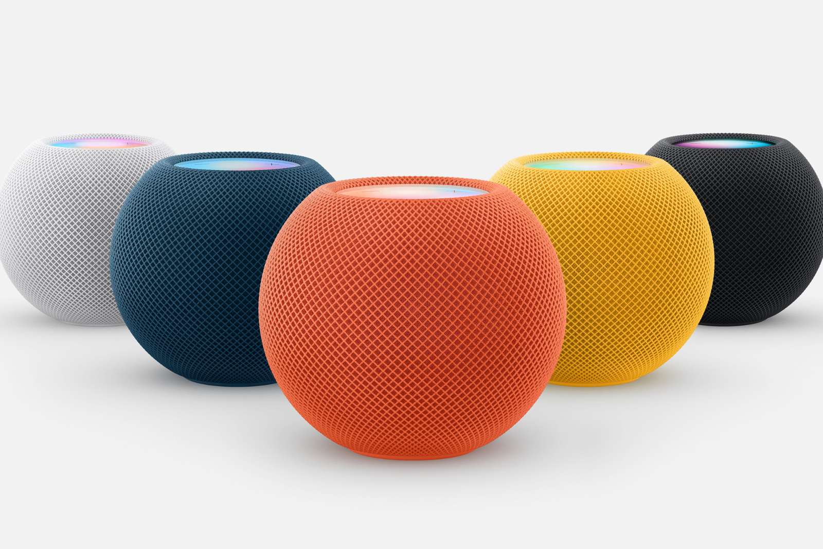 Homepod d'Apple assis sur une table blanche dans toutes les couleurs.