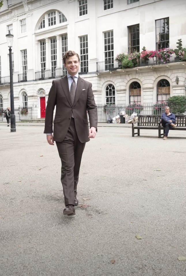 Jonas Froelich Hiltner marchant à Londres dans un costume brun sur mesure
