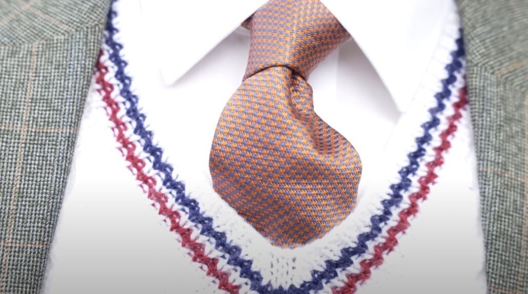 Gros plan de la cravate à motifs en pas de micro-hound d'orange et bleu d'Elliot