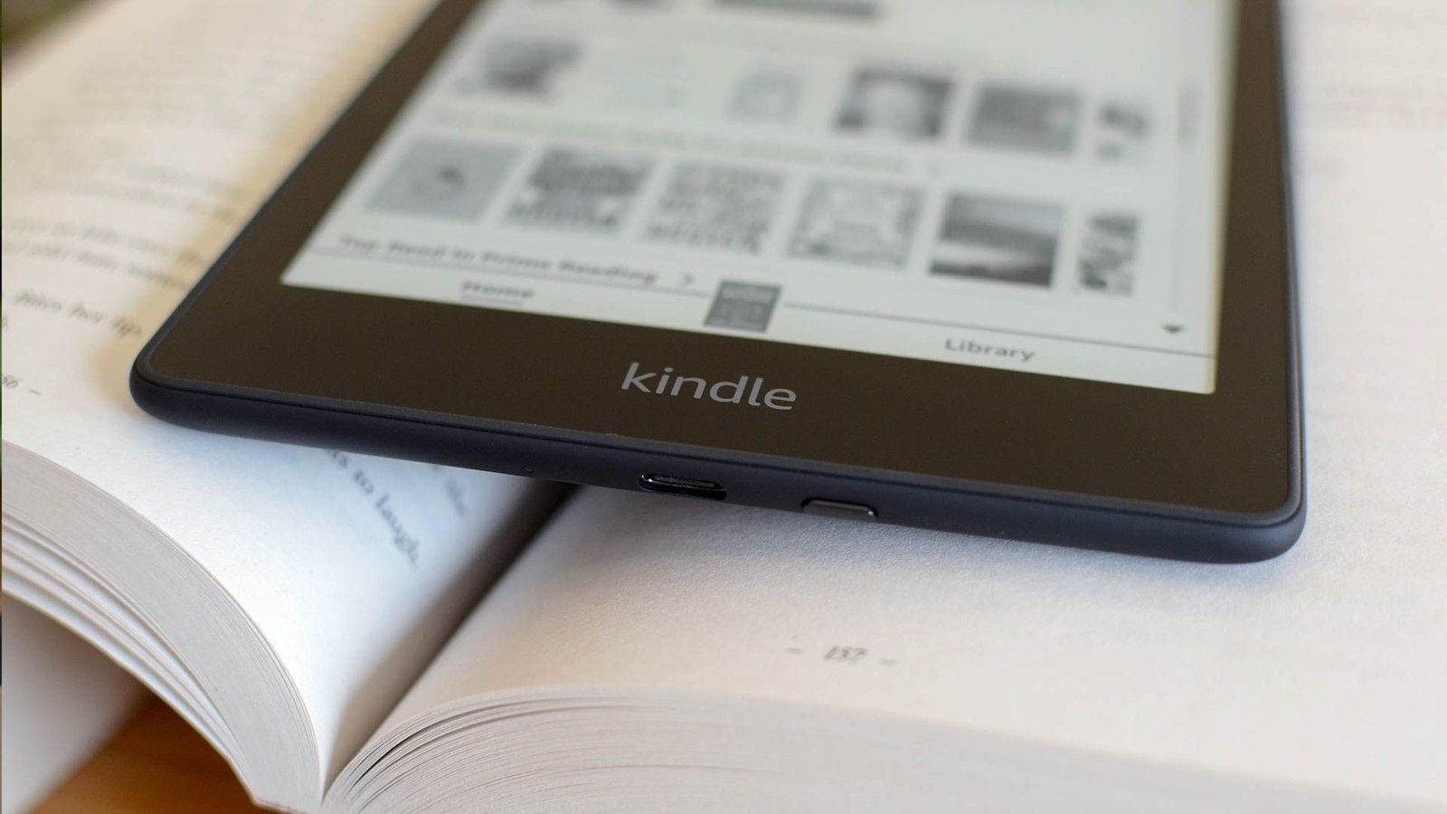Un Kindle Ereder sur un livre papier.