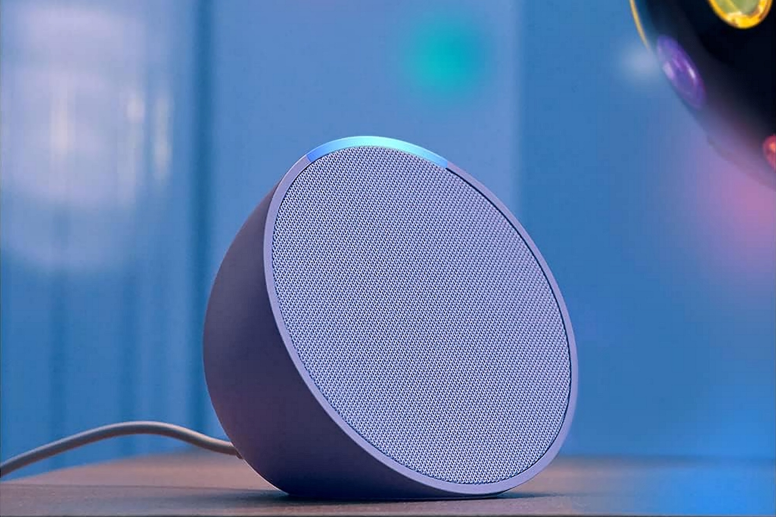 Un point d'écho Amazon avec une lumière disco en arrière-plan.