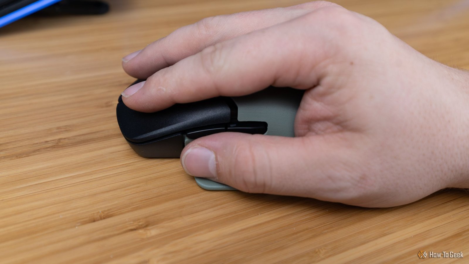 Une main sur la souris de jeu sans fil Hyperx PulseFire Saga Pro.