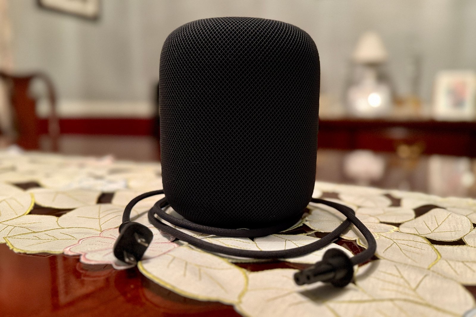 Le homepod étant enveloppé dans son câble détachable.