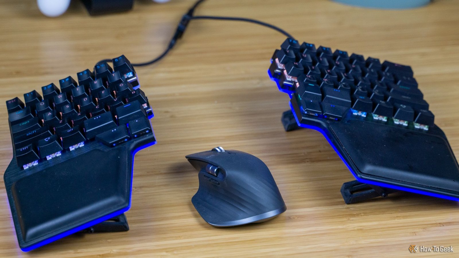 Le clavier Dygma Riase assis sur un bureau avec une souris entre les moitiés.