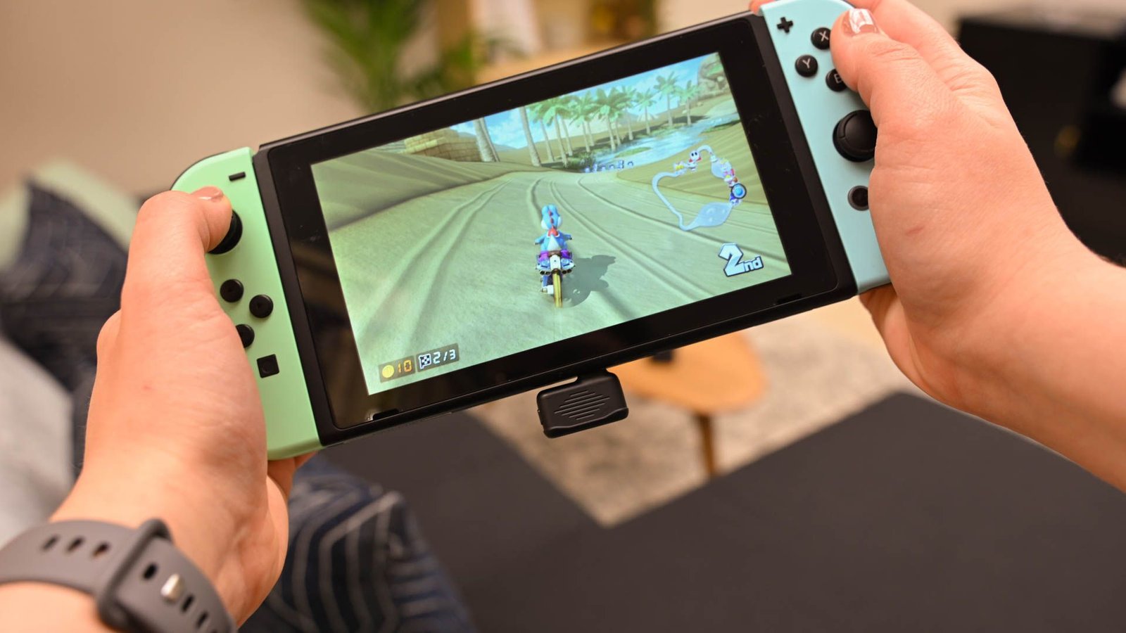 Personne jouant Mariokart sur un interrupteur Nintendo avec le dongle sans fil USB du JBL Quantum TWS branché