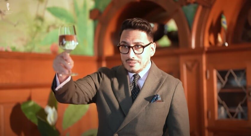 Ivan soulevant un verre avec contact visuel et un sourire comme alternative respectueuse aux lunettes de tir.