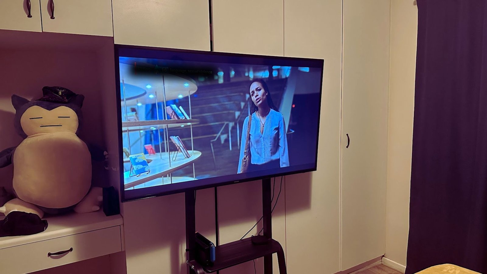 Photo d'une télévision dans une chambre sur un stand roulant.