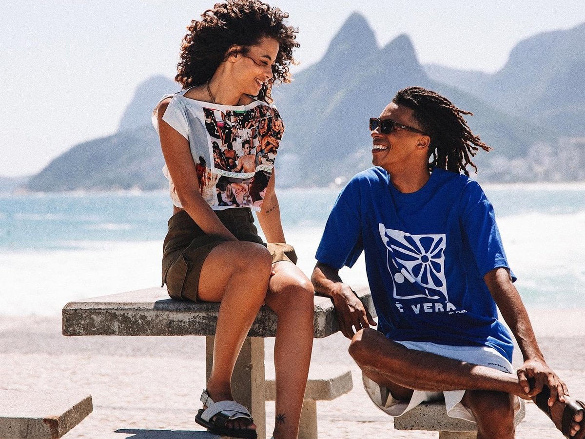 Modèle féminin dans un crop top graphique et un short brun et un modèle masculin dans une chemise graphique bleue et un short blanc
