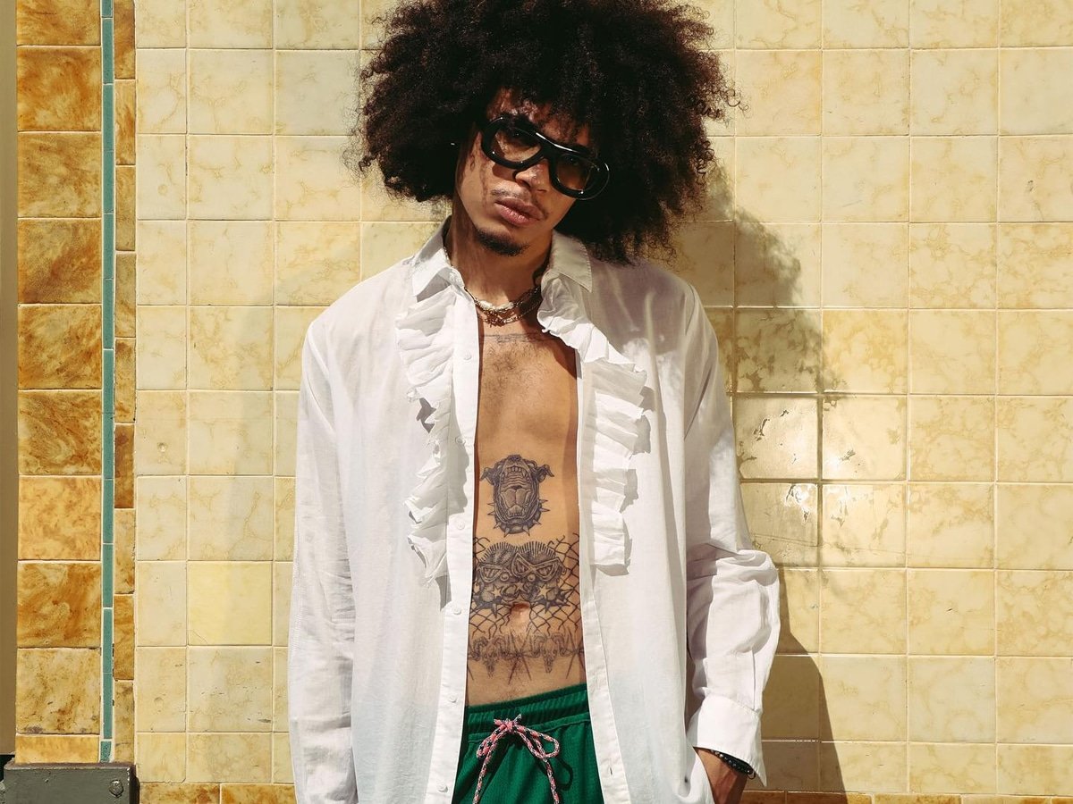 Modèle masculin dans une chemise à manches longues blanches et un short vert