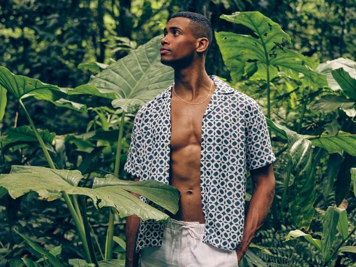 Modèle masculin dans une chemise imprimée à motif bleu et short blanc
