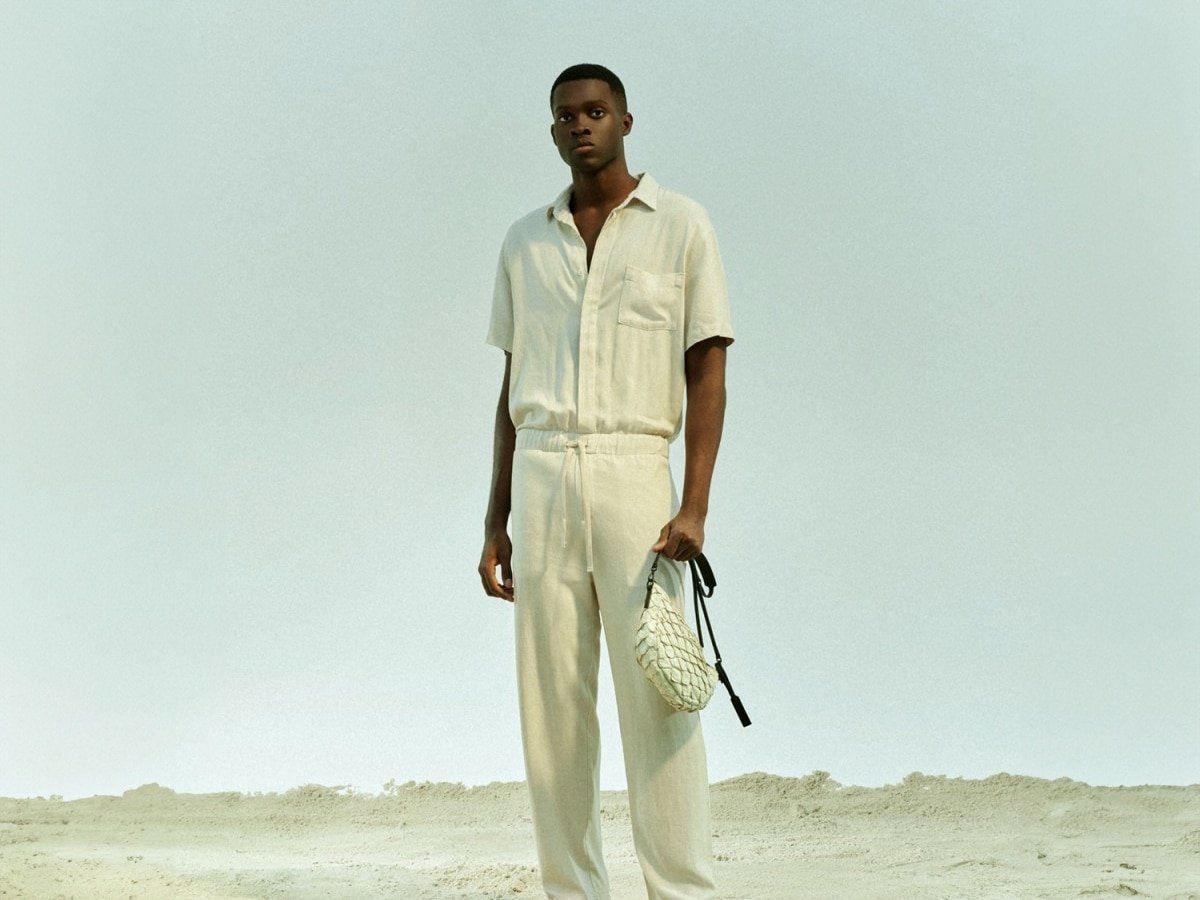 Modèle masculin dans une chemise blanche nichée dans un pantalon blanc