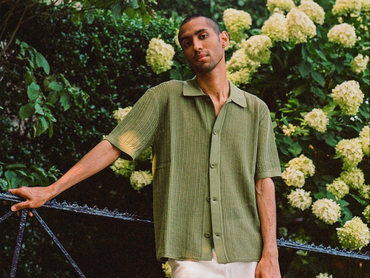 Modèle masculin dans une chemise tricotée verte et un short blanc