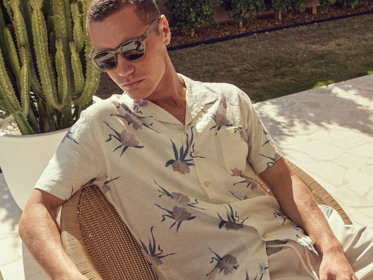 Modèle masculin dans une chemise à motifs de fleurs blanches