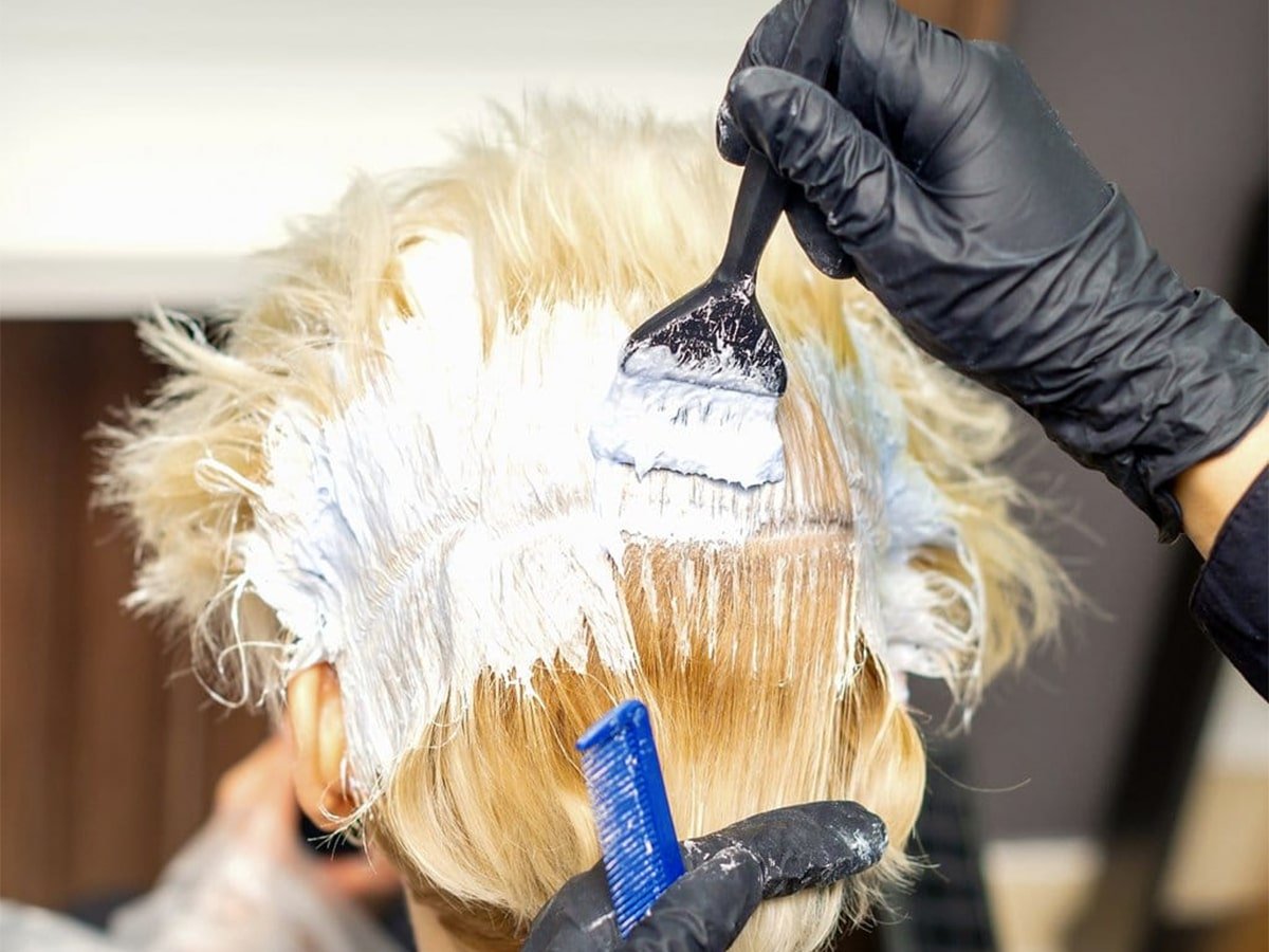 Coiffeur blanchissant les cheveux du client
