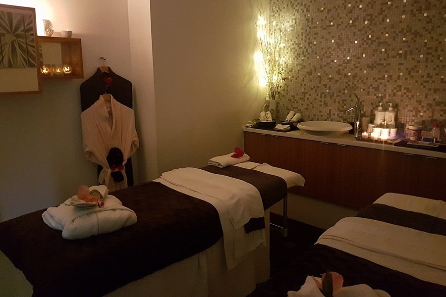 Salle de massage sombre avec robes de lit simple suspendu
