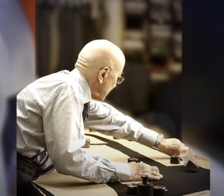 Rudolf Niedersüß se penche sur une table de coupe fixant un motif avec des poids de fer dans la salle de travail de Kniže.