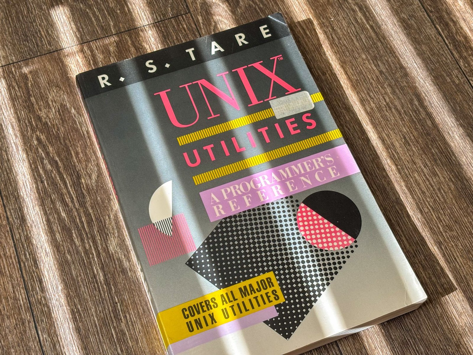 Un livre intitulé "Unix Utilities" par RS Tare, avec un design vintage avec des formes géométriques.