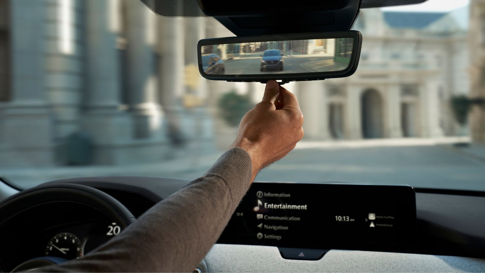 Close-up Shot d'un conducteur ajustant le rétroviseur numérique dans une Mazda CX-90 2025.