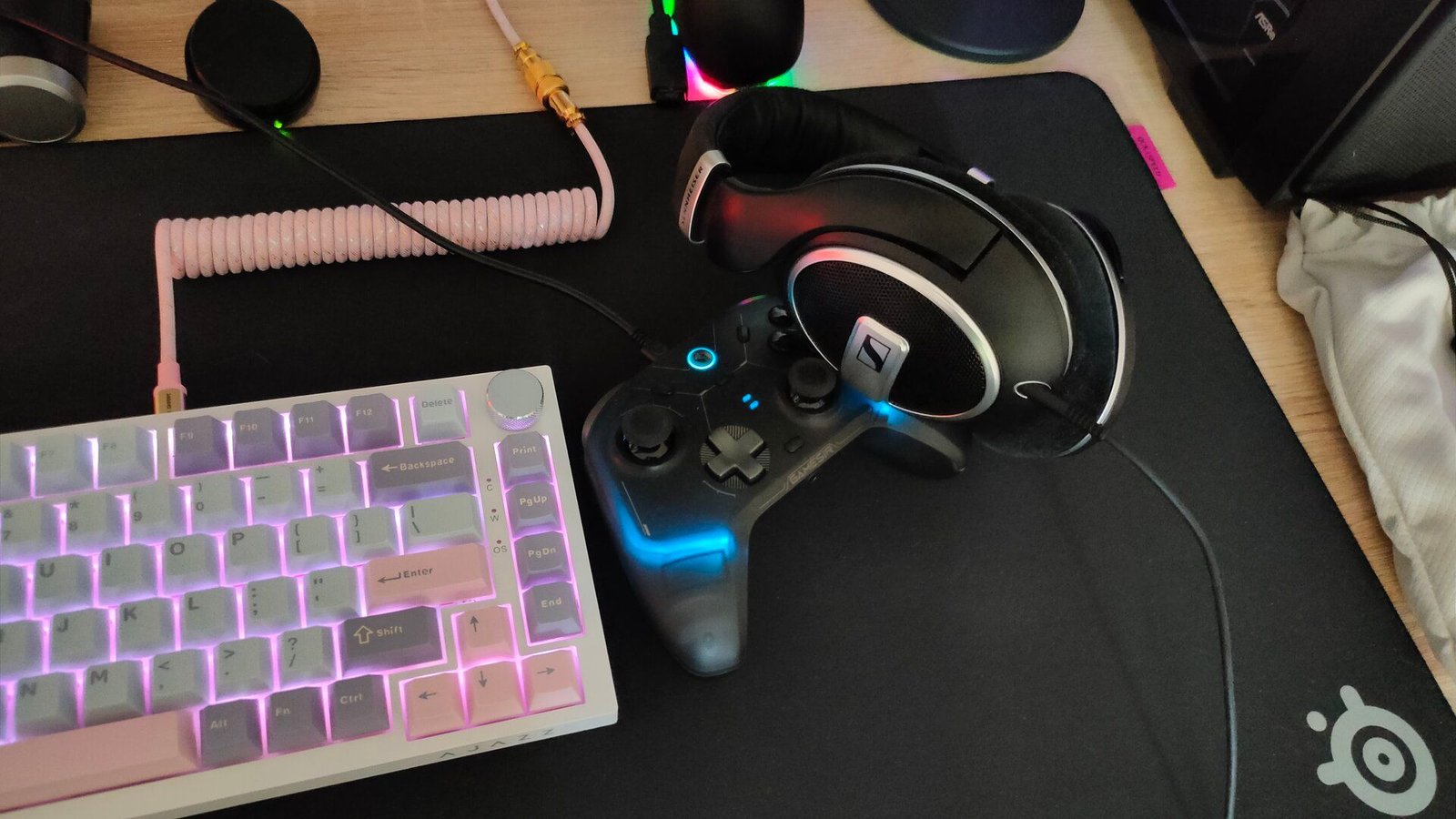 Un clavier câblé, un contrôleur et des écouteurs sur une souris noire.