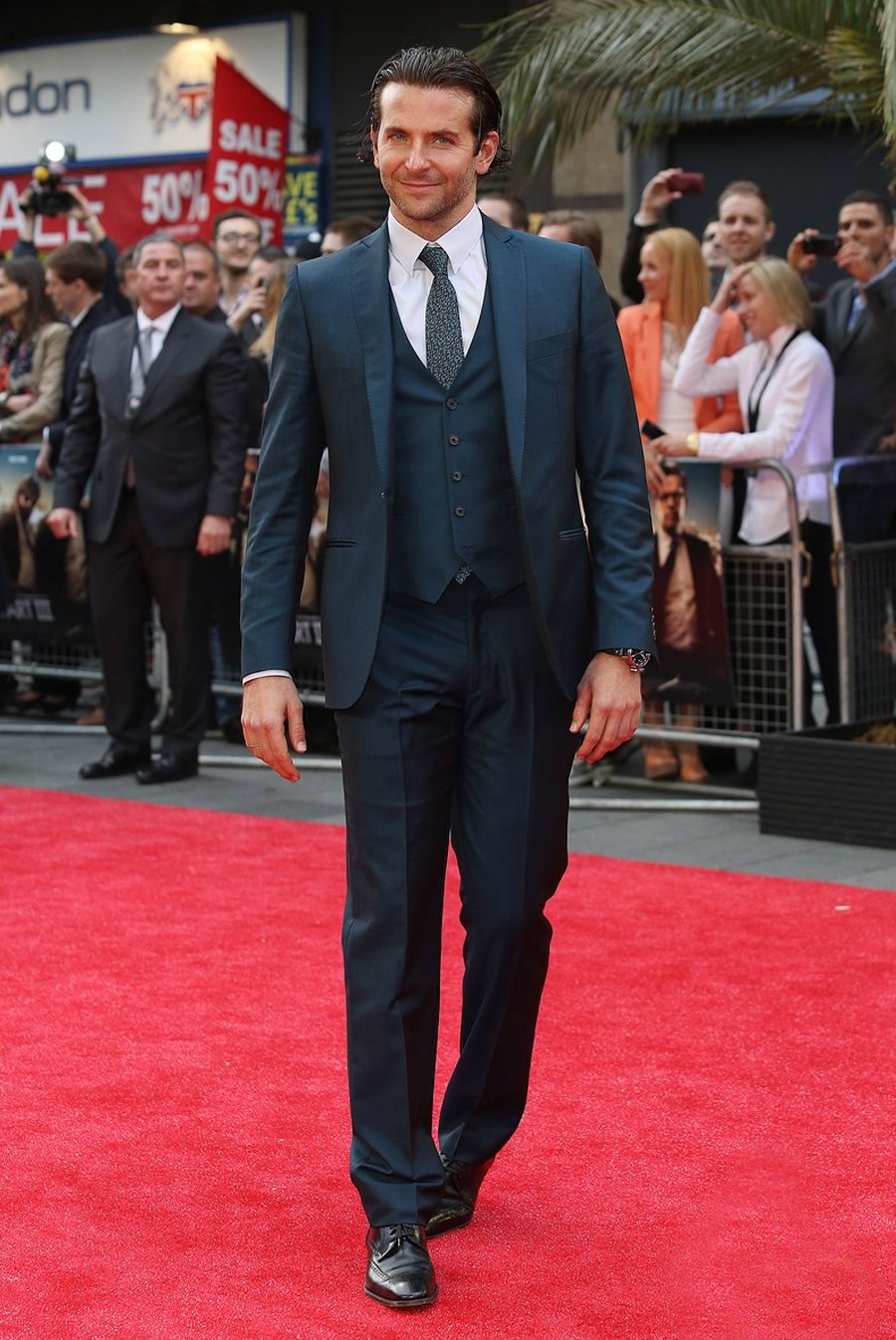 Bradley Cooper dans un costume gris sur un tapis rouge