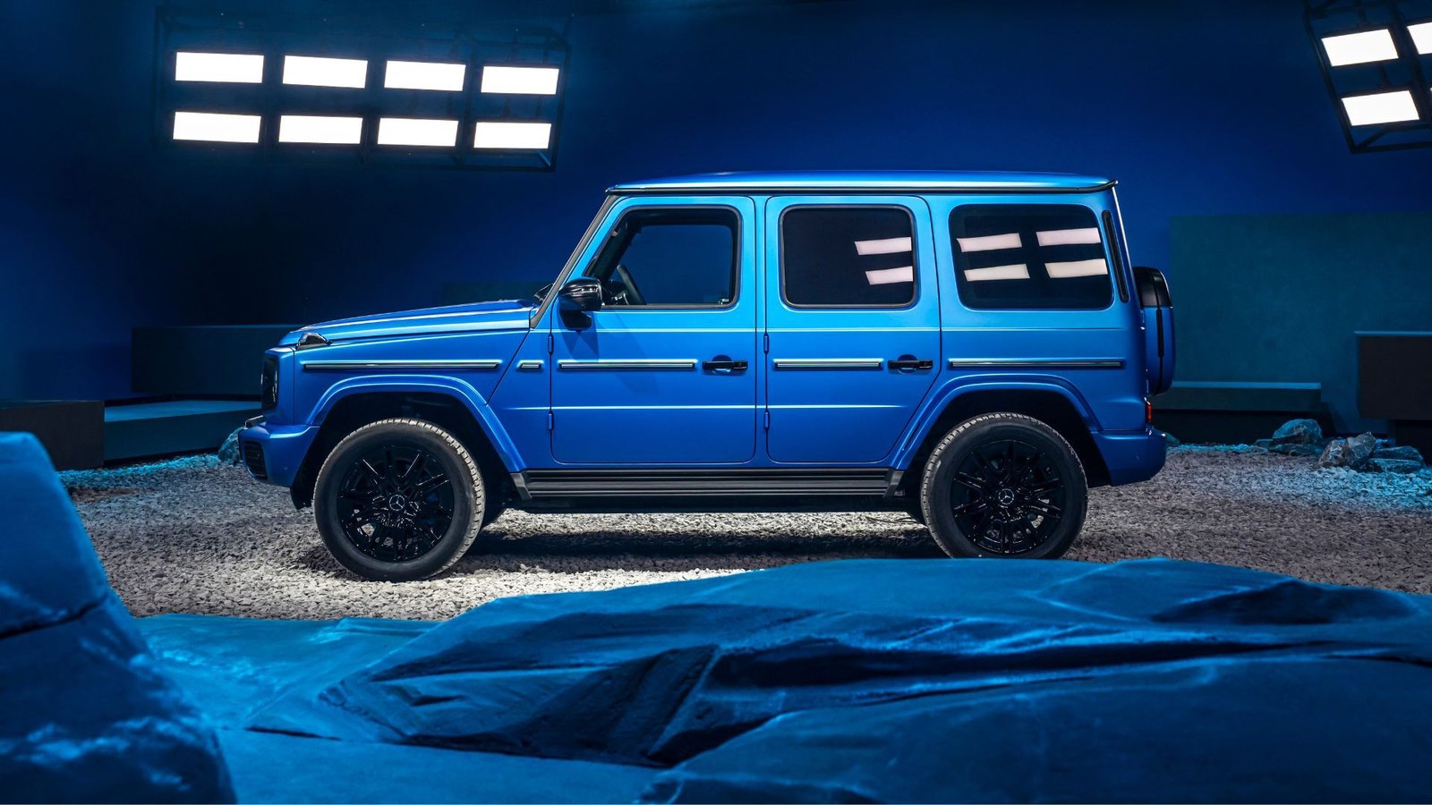 Profil latéral statique Disque d'une Mercedes-Benz G580 EQ bleue en studio.