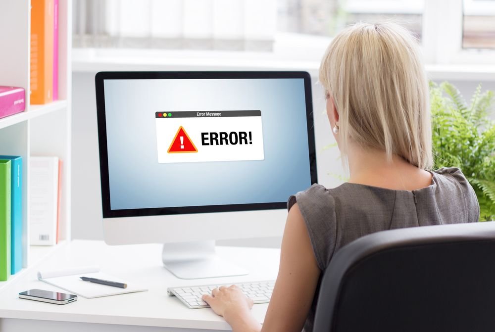Une femme regarde un message d'erreur sur son mac.