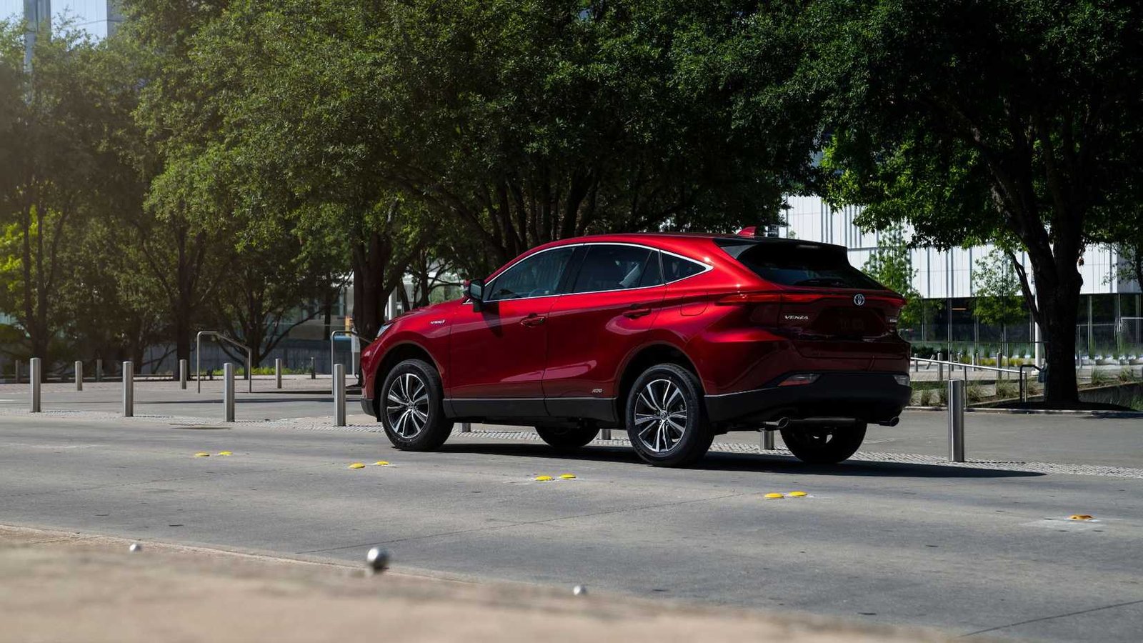 Arrière statique 3/4 tir d'une Toyota Venza rouge 2021 garée dans une rue dans une ville.