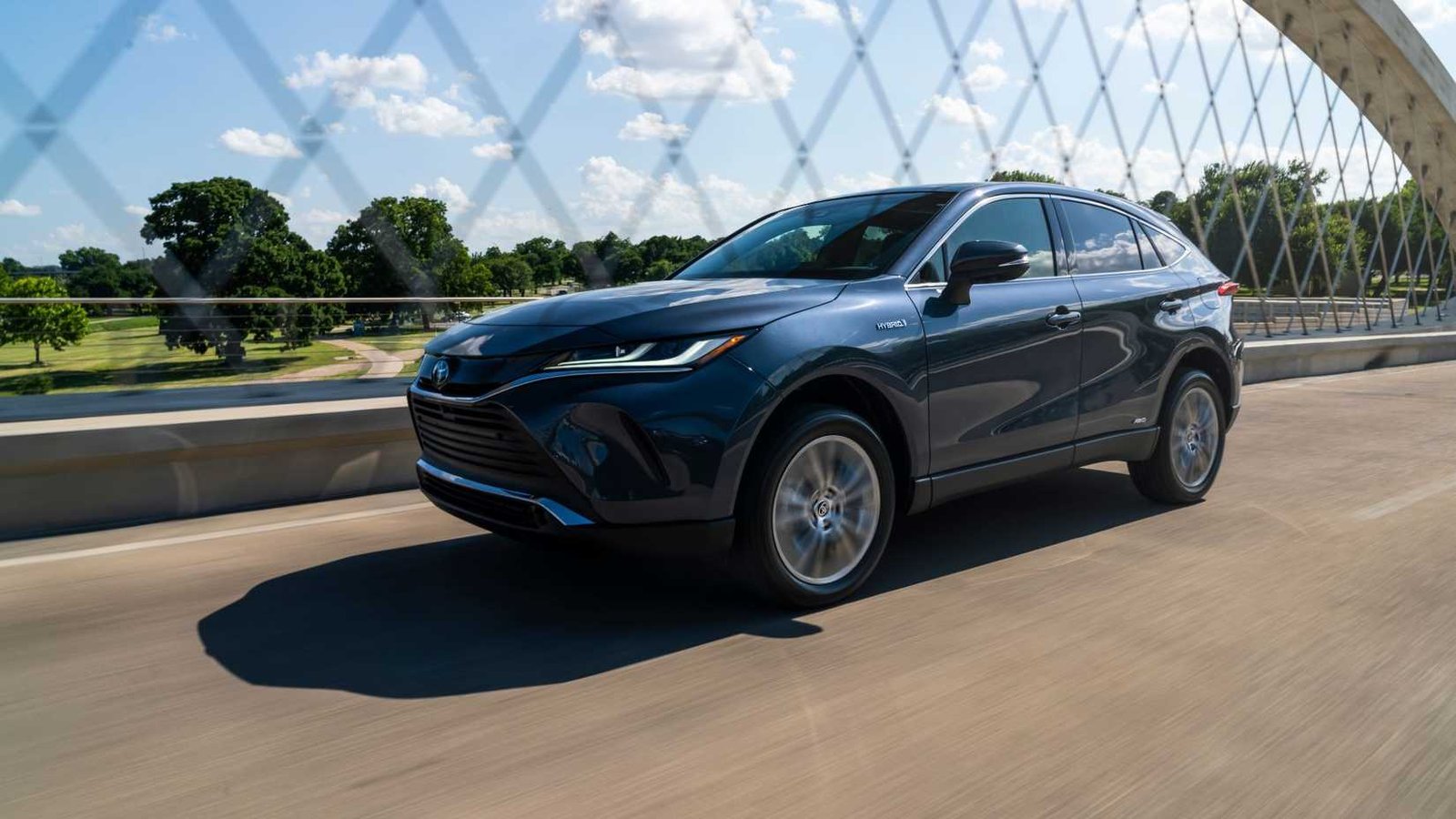 Front dynamique 3/4 tir d'une Toyota Venza bleue 2021 conduisant sur un pont.