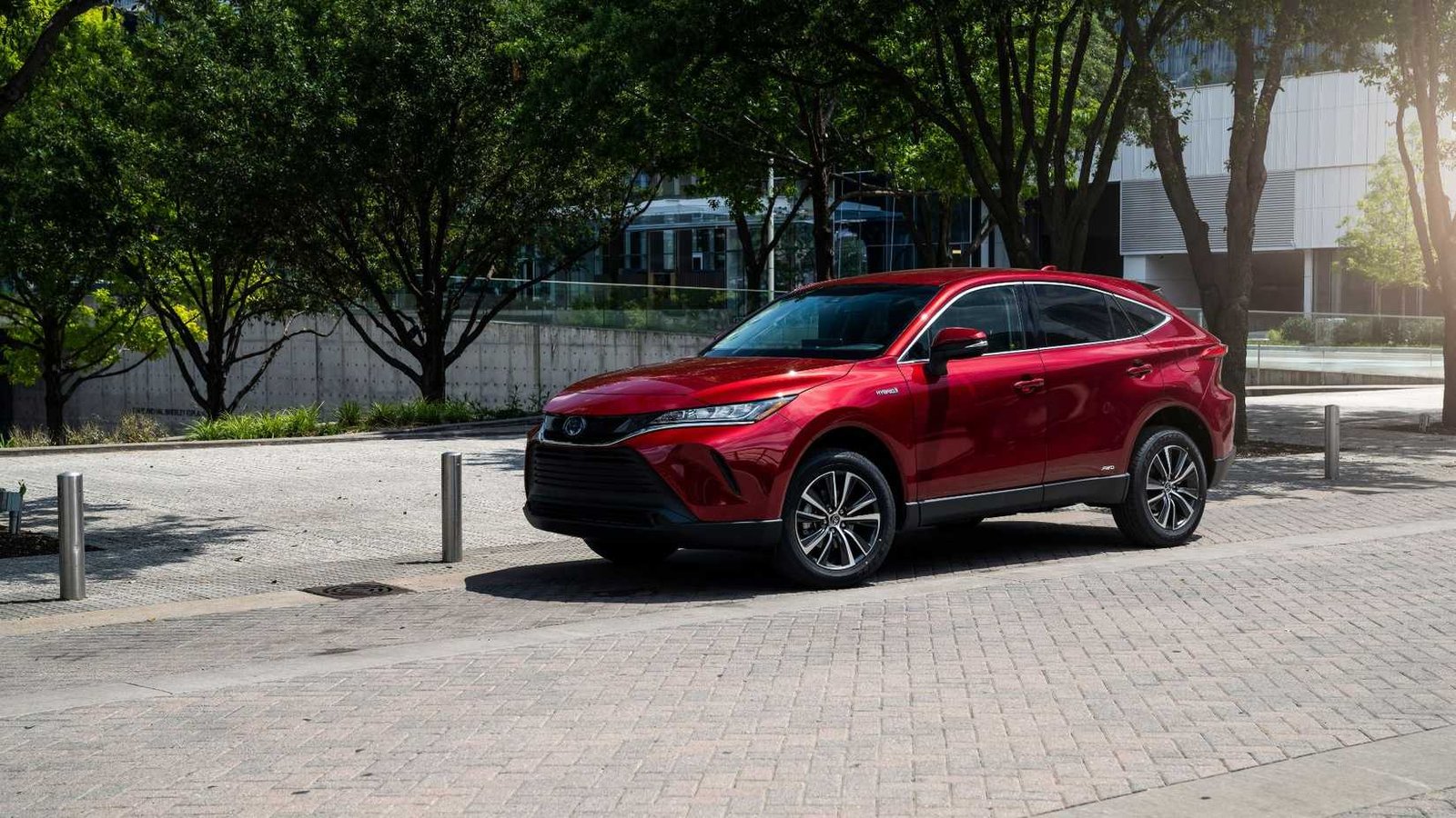 Front statique 3/4 coup d'une Toyota Venza rouge 2021 garée dans une rue dans une ville.