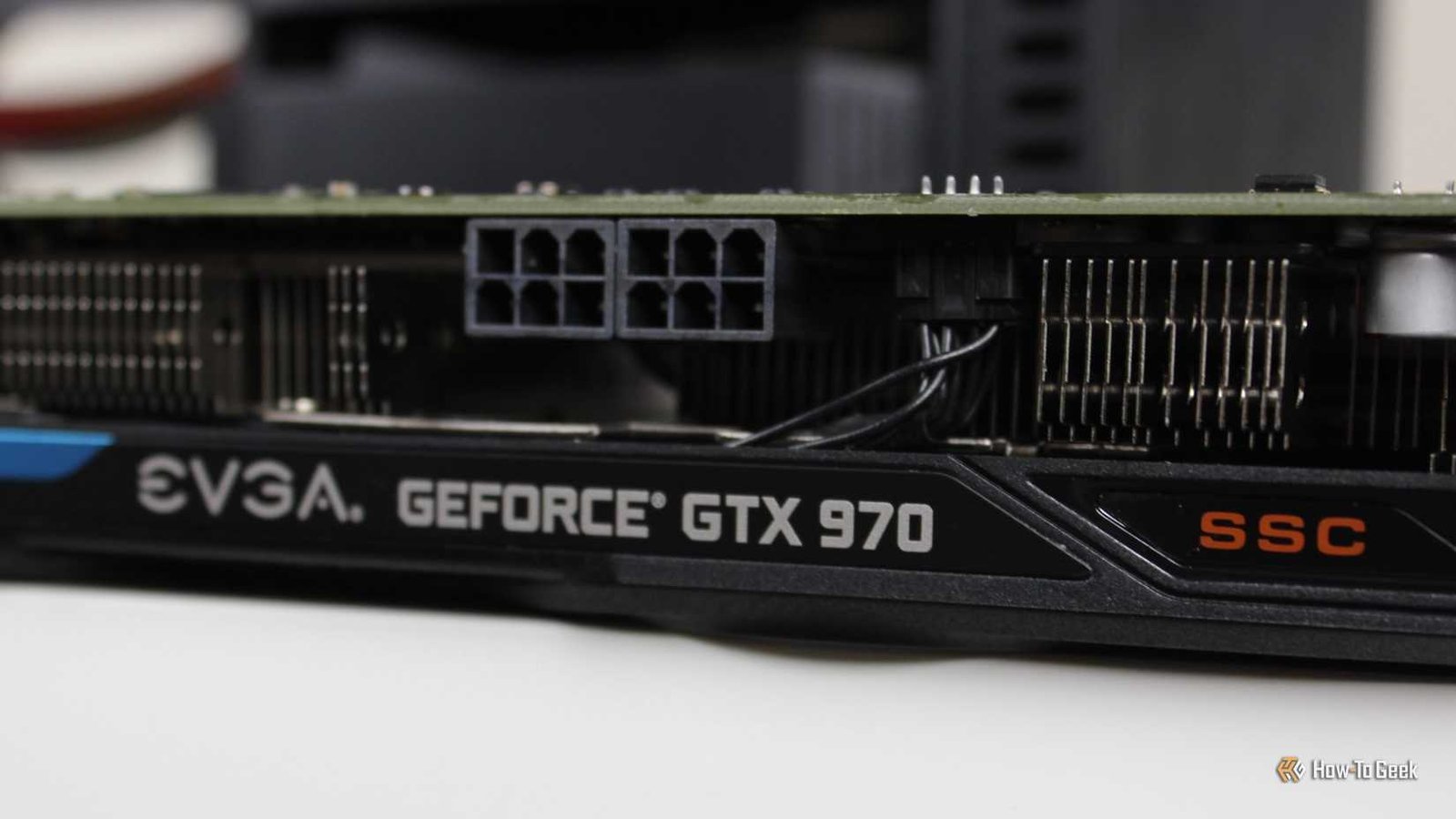 Le côté de la carte graphique EVGA NVIDIA GEFORCE GTX 970 SSC GAMING ACX 2.0 assis sur un bureau.