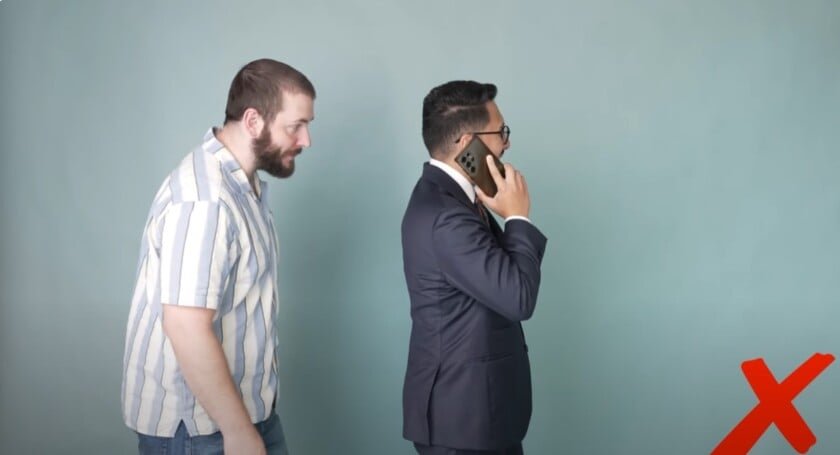 L'homme en costume sur téléphone bloquant la passerelle piéton et perturbant le flux de trafic.