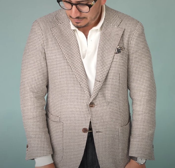 Ivan portant un manteau de sport à forfait léger avec une chemise blanche et un carré de poche à motifs.