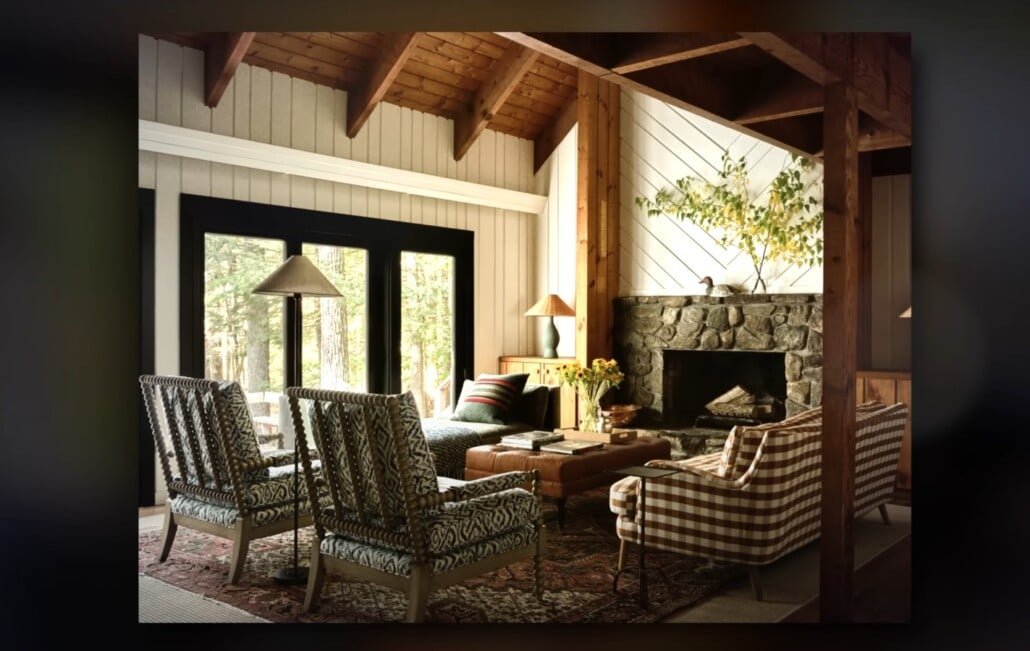 Fiche de pierre de salon rustique Salon rustique avec poutres exposées, chaises à motifs et cheminée en pierre