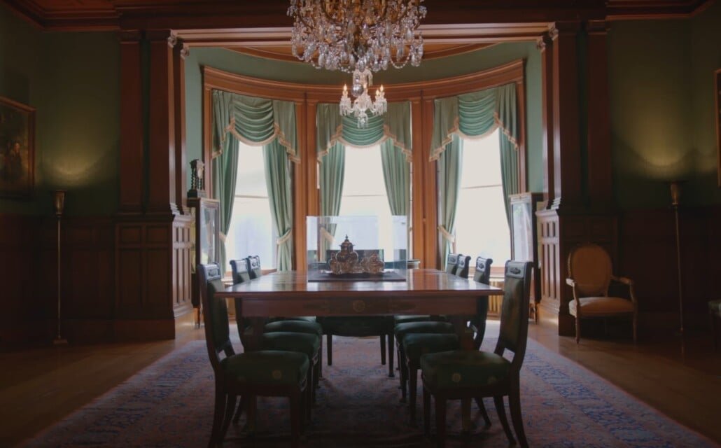 Salle à manger formelle traditionnelle Salle à manger formelle traditionnelle avec lustre, fenêtres drapées et longue table en bois.