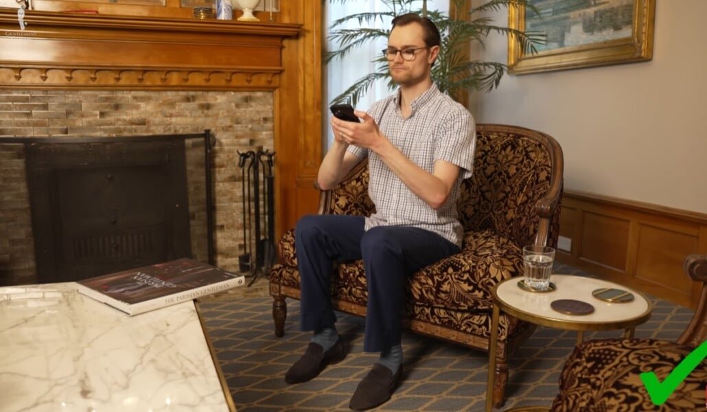 Posture verticale appropriée Homme assis droit avec le dos droit tout en tenant le téléphone au niveau des yeux.