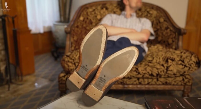 Pieds sur des chaussures de table visibles Souget à chaussures de repos sur une table tout en se penchant en arrière dans la chaise