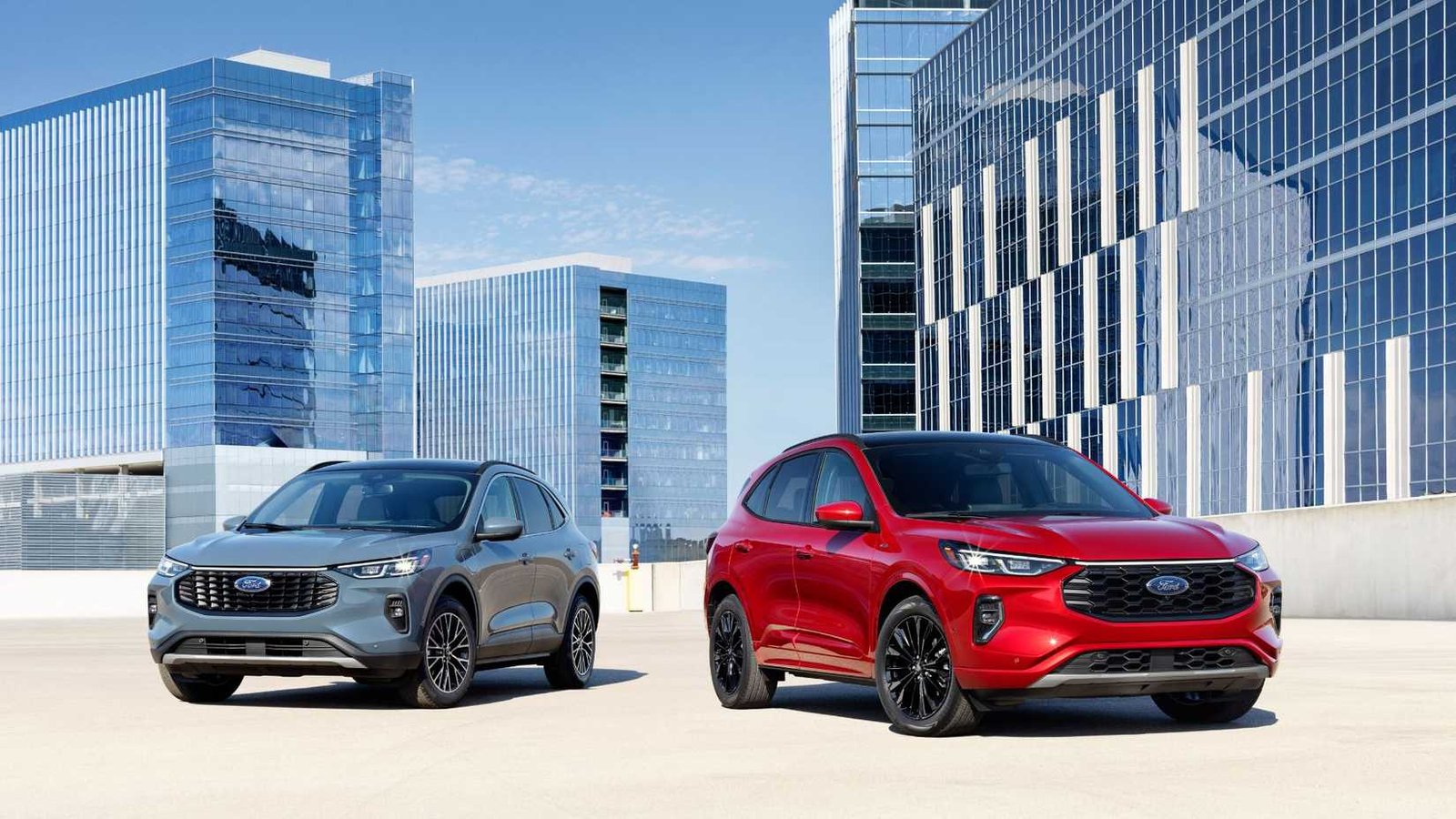 Tiche statique de deux modèles Ford Escape 2023 - Blue, un rouge - côte à côte avec des immeubles de grande hauteur en arrière-plan.