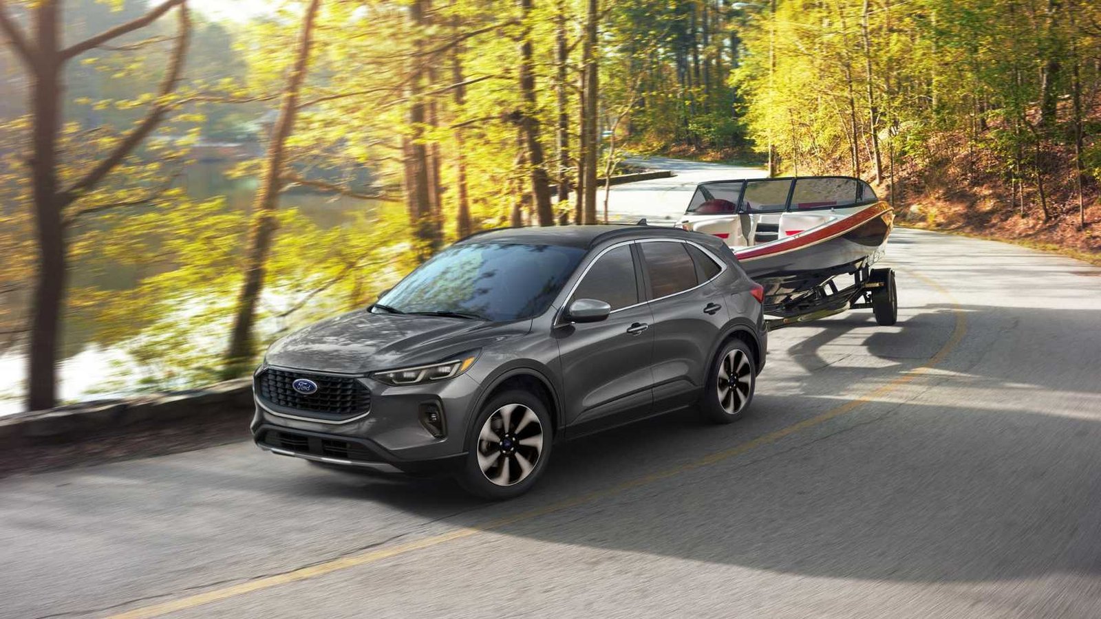 Front dynamique 3/4 tir d'une Ford Escape gris 2025 Platinum remorquant un bateau sur une route de campagne.