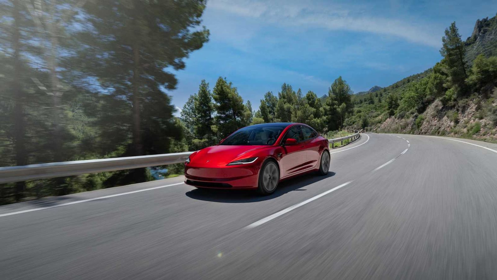 Avant 3/4 THOT ONE ROUGE 2024 TESLA TESLA MODÈLE 3 CONDUITE SUR UNE ROUTE COUNTRIELLE.