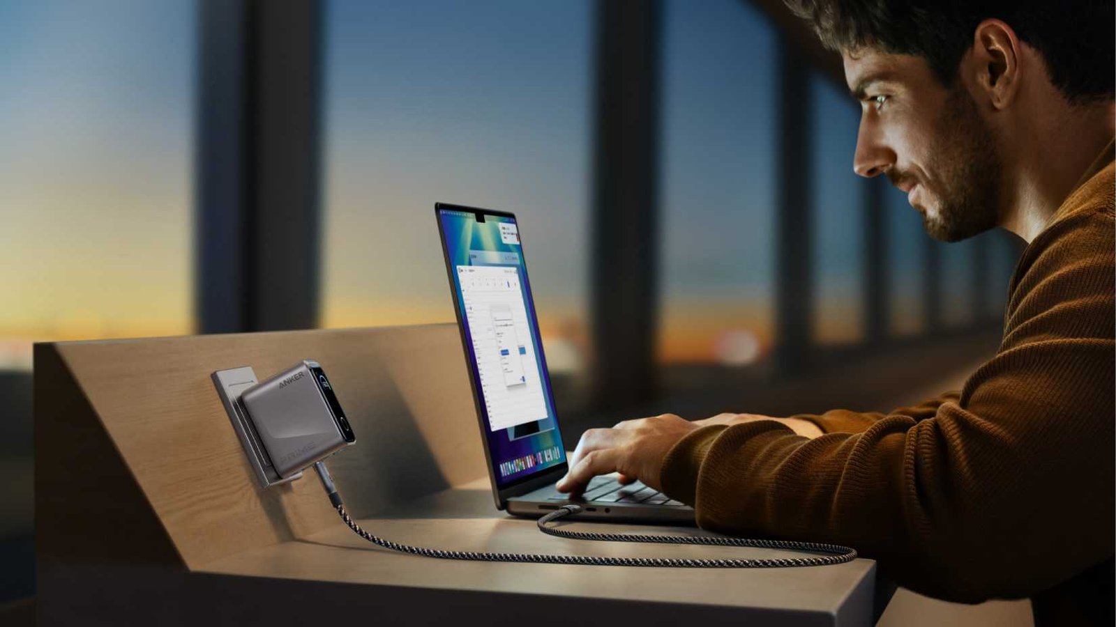 Personne utilisant un ordinateur portable branché sur le chargeur Anker Prime. 