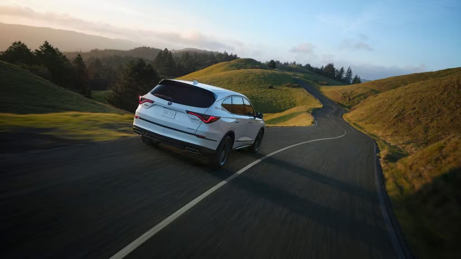 Plan 3/4 arrière dynamique d'une Acura MDX A-Spec 2025 blanche.