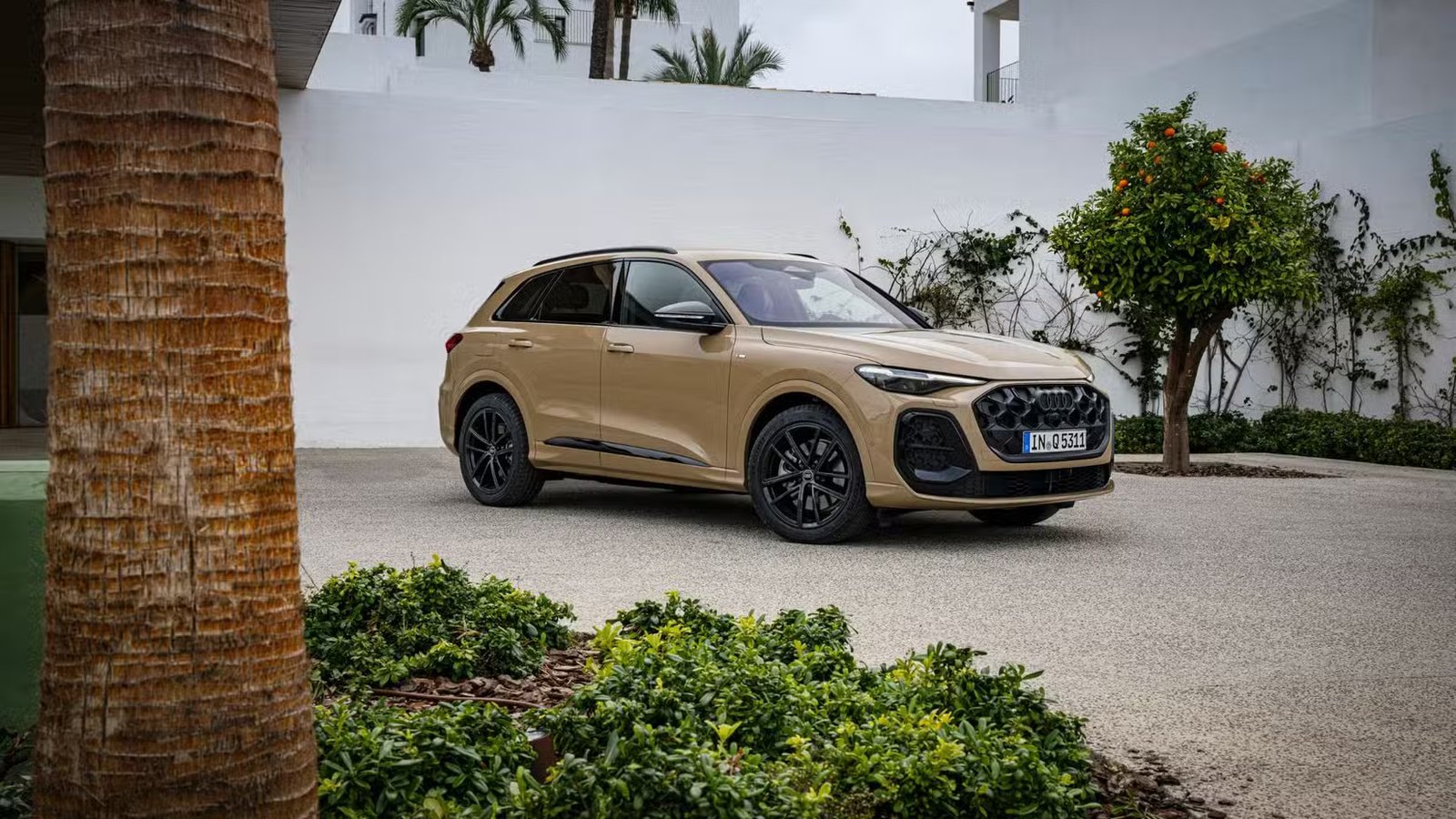 Plan 3/4 avant statique d'une Audi Q5 beige.