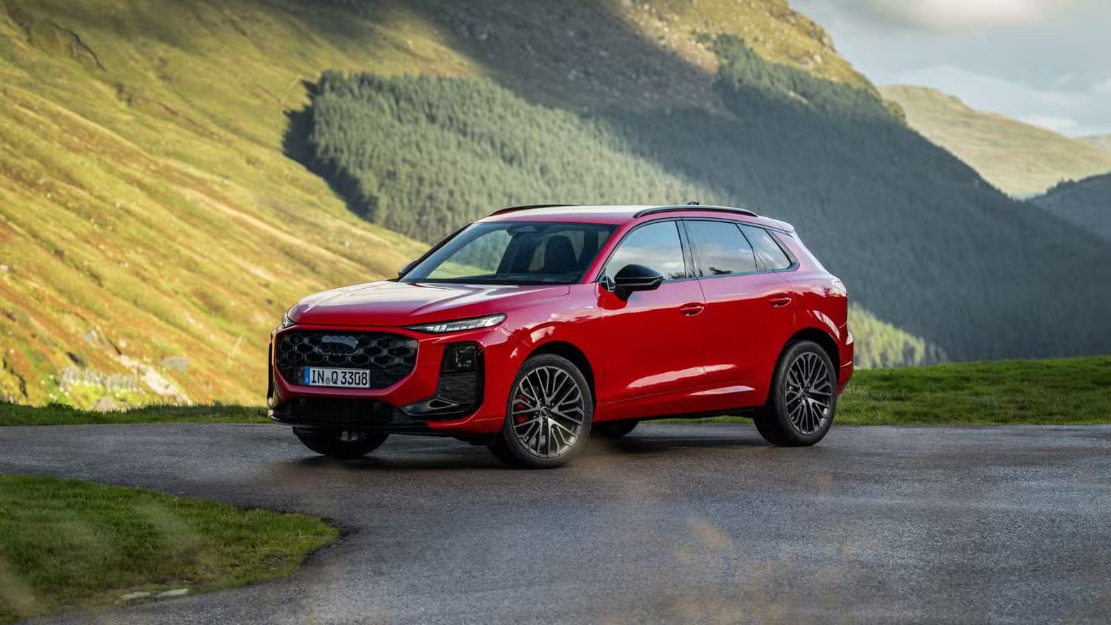 Plan statique 3/4 avant d'une Audi Q3 2026 rouge.