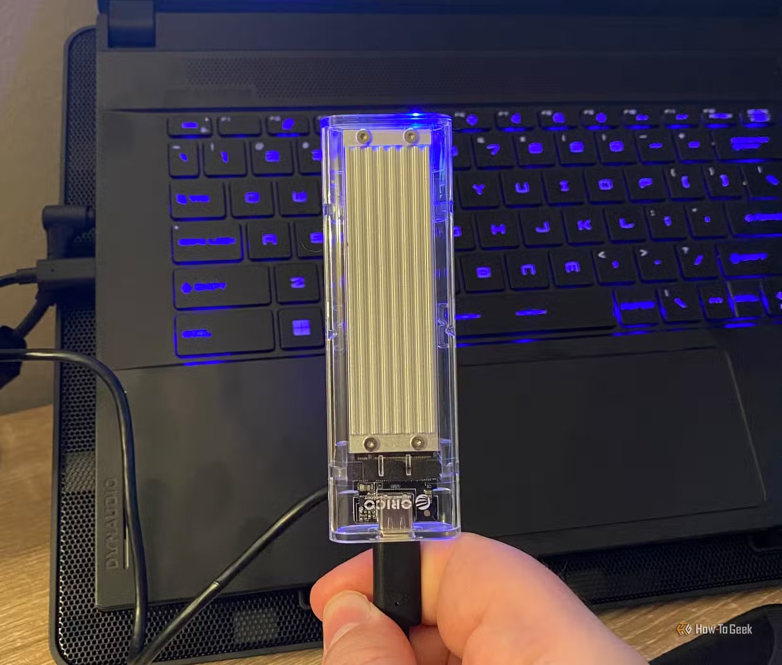 Un SSD USB NVMe devant un ordinateur portable de jeu
