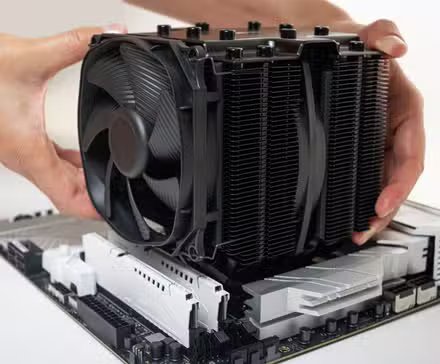 Un grand refroidisseur de processeur à air est en cours d'installation sur une carte mère.