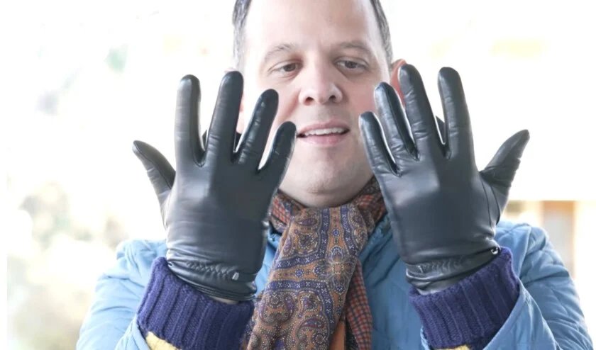 Raphael Schneider inspectant sa première paire de gants en cuir noir.